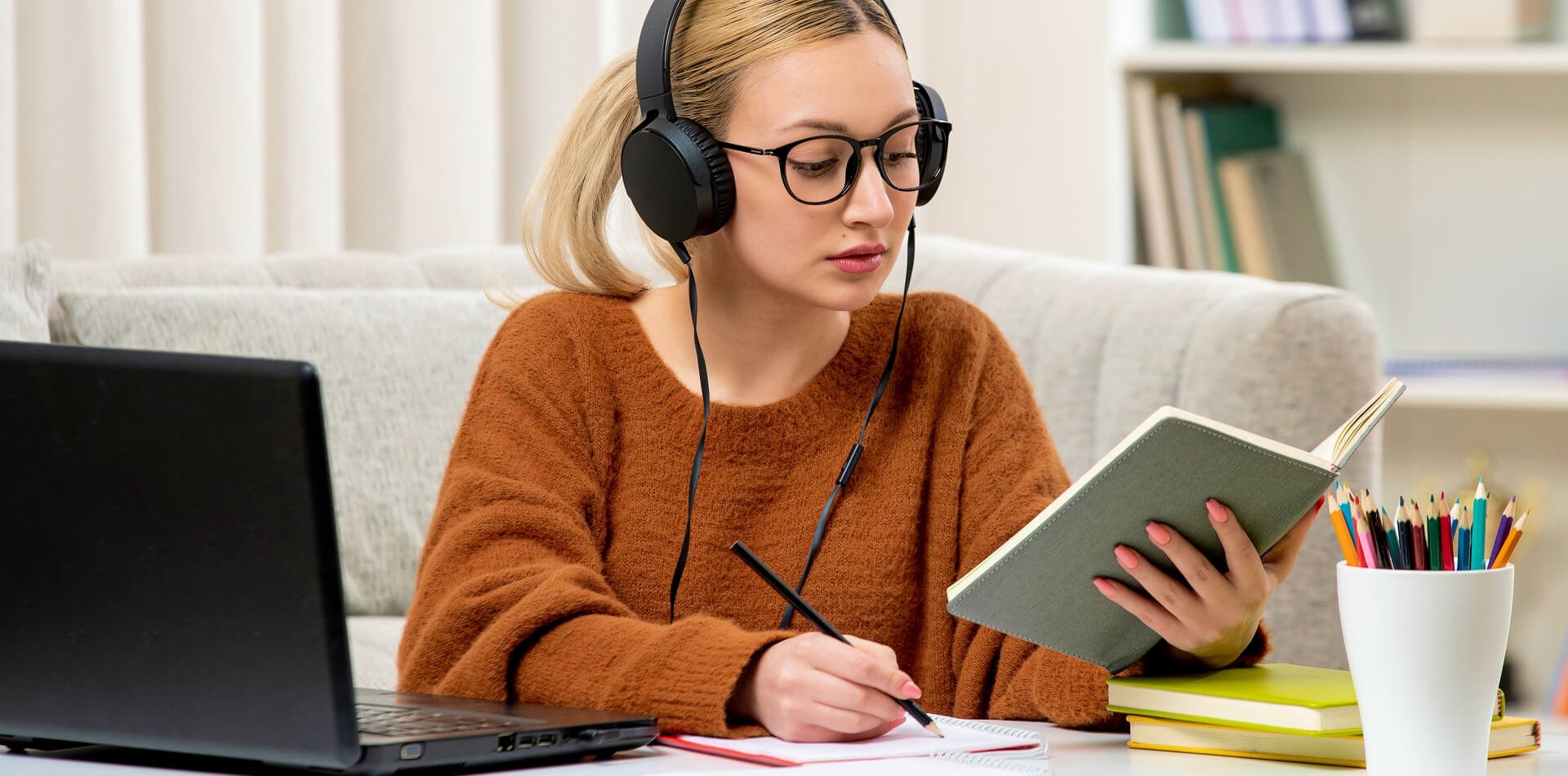 Student learning with books and a laptop