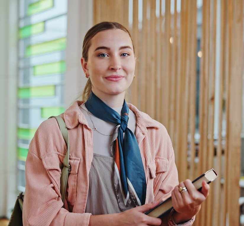 Student holding books in a modern learning environment